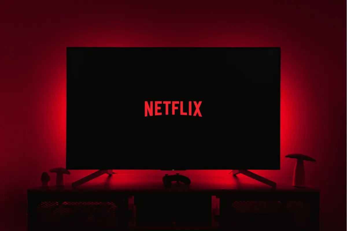 Tendencias en Netflix 2025 en un cuarto iluminado de rojo (Foto: Canva)