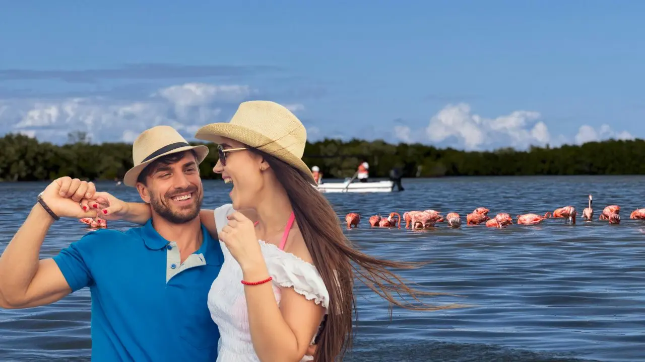 Al fondo, una vista de los flamencos en una zona de Río Lagartos en Yucatán. Al frente, turistas disfrutan de un momento agradable.- Fuente Irving Gil y Canva