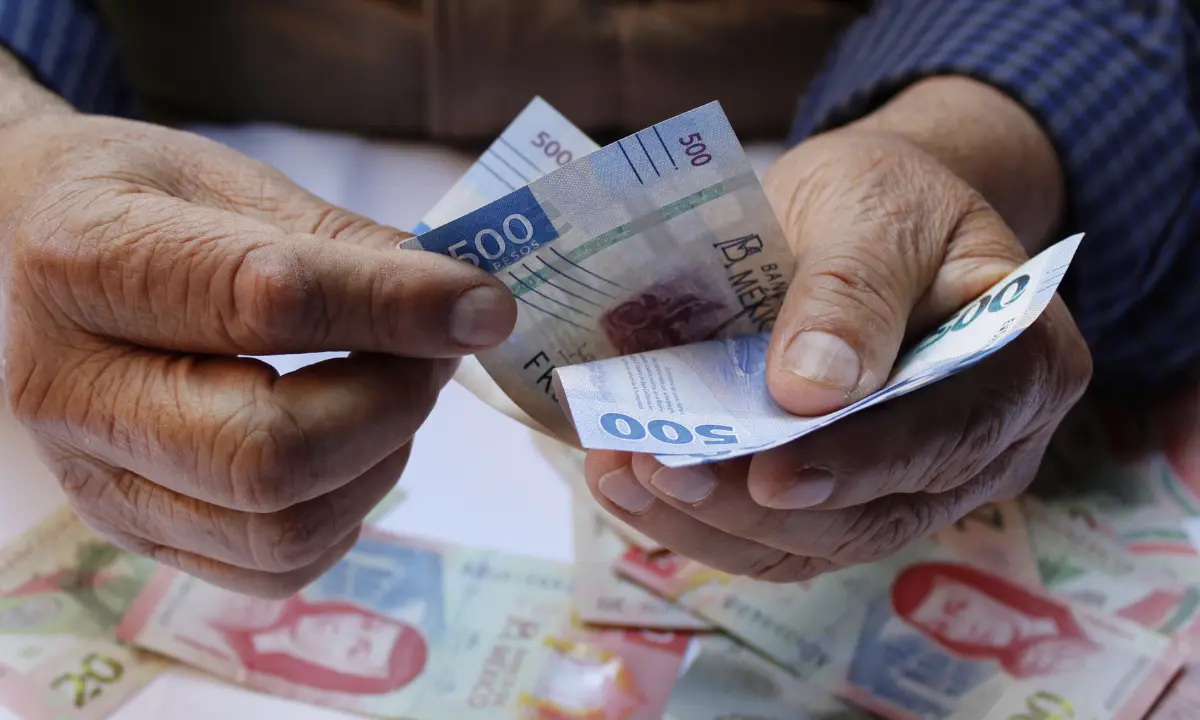 Persona contando billetes de 500 y 100 pesos mexicanos Foto: Canva