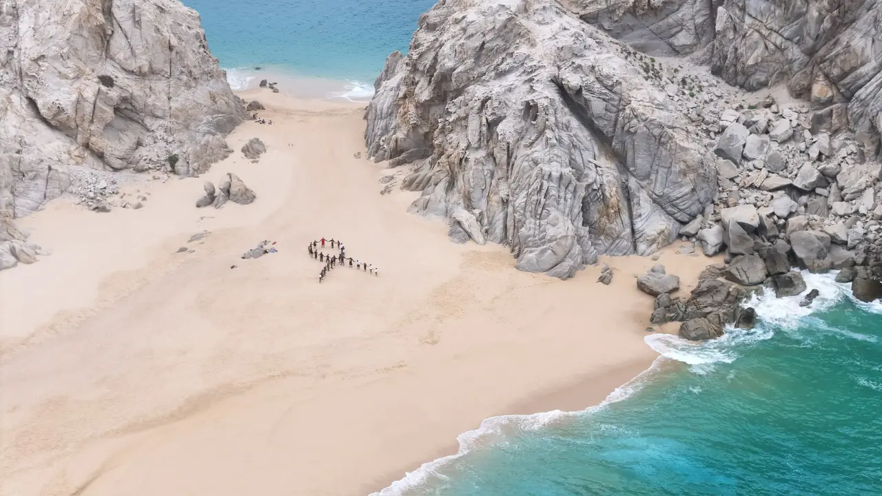 La División Juvenil y voluntarios del Cuerpo de Bomberos de Cabo San Lucas replicaron el moño azul en tierra, en una intervención simultánea realizada en Playa del Divorcio. Foto: Cuerpo de Bomberos de Cabo San Lucas / Facebook