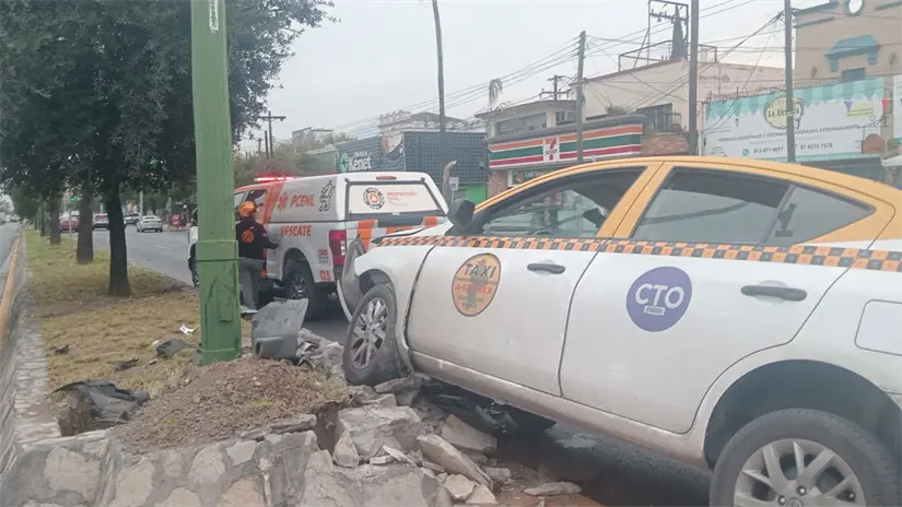 imagen recuadro El taxi quedó casi encima de una jardinera en la Calzada Madero, en el centro de Monterrey. Foto: Protección Civil de Nuevo León