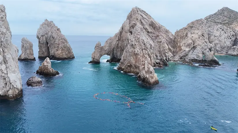imagen recuadro Más de 120 nadadores y nadadoras llegaron hasta El Arco de Cabo San Lucas para crear un moño azul humano en el mar y visibilizar la importancia de la detección temprana del cáncer. Foto: Cuerpo de Bomberos de Cabo San Lucas / Facebook