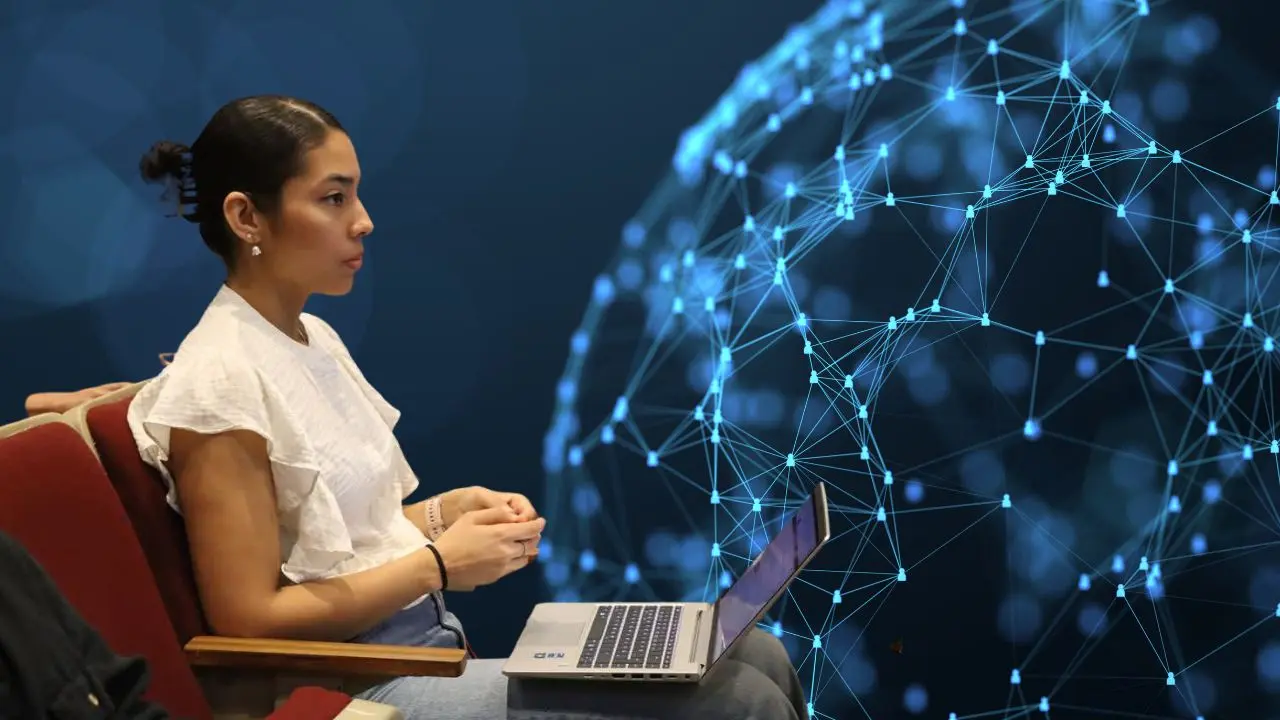 Una joven usa su computadora durante un evento en Yucatán para informar sobre el acceso tecnológico.- Fuente Christian Espadas y Canva