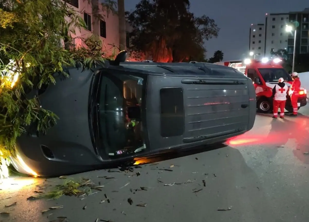 El incidente no solo provocó que el vehículo terminara volcado, sino también el derrumbe de un árbol. Foto: Protección Civil de Monterrey.