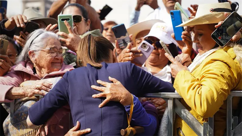 imagen recuadro Claudia Sheibamu siendo abrazada por grupo de mujeres en el evento. FOTO: Laura Ávila