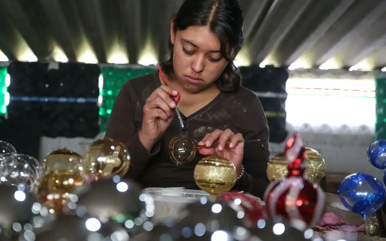 En el taller Tolontli de Xonacatlán puedes aprender a soplar vidrio para crear y decorar tu propia esfera navideña. Foto: Ramsés Mercado / X@Agencia 24mm (Canva)