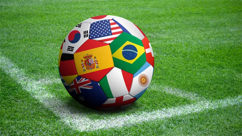 imagen recuadro Imagen ilustrativa de balón de futbol con banderas de diversos países/Foto: IA Canva