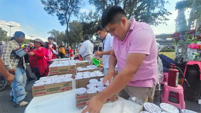 Vecinos en Iztapalapa regalan comida a peregrinos que pasan por Iztapalapa, en camino a la Basílica de Guadalupe. | Foto:  Luis Antonio Alfaro