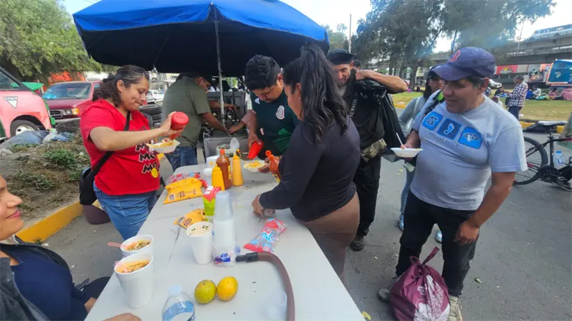 Vecinos en Iztapalapa regalan comida a peregrinos que van en camino a la Basílica de Guadalupe. | Foto:  Luis Antonio Alfaro