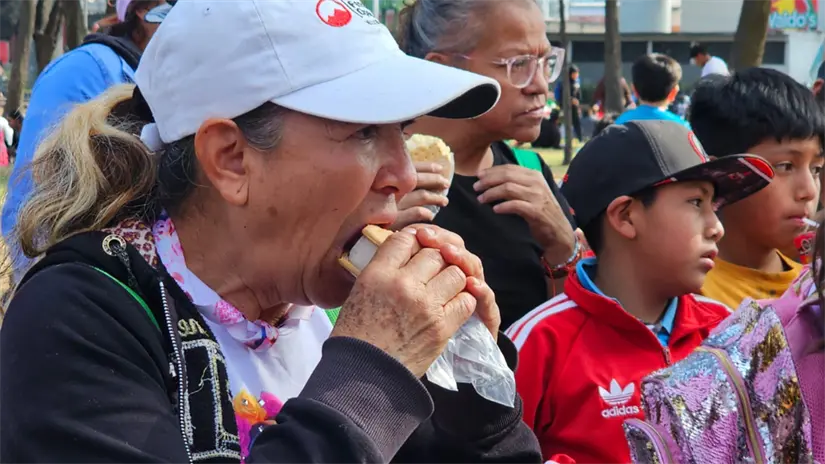 Mujer comiendo alimentos que los vecinos de Iztapalapa están ofreciendo. | Foto:  Luis Antonio Alfaro