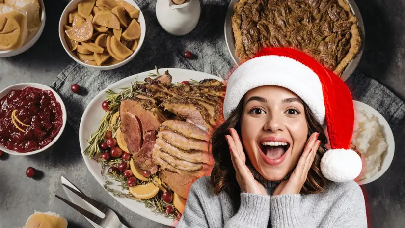 Una mujer feliz con un sombrero de navidad y detrás una cena de Navidad