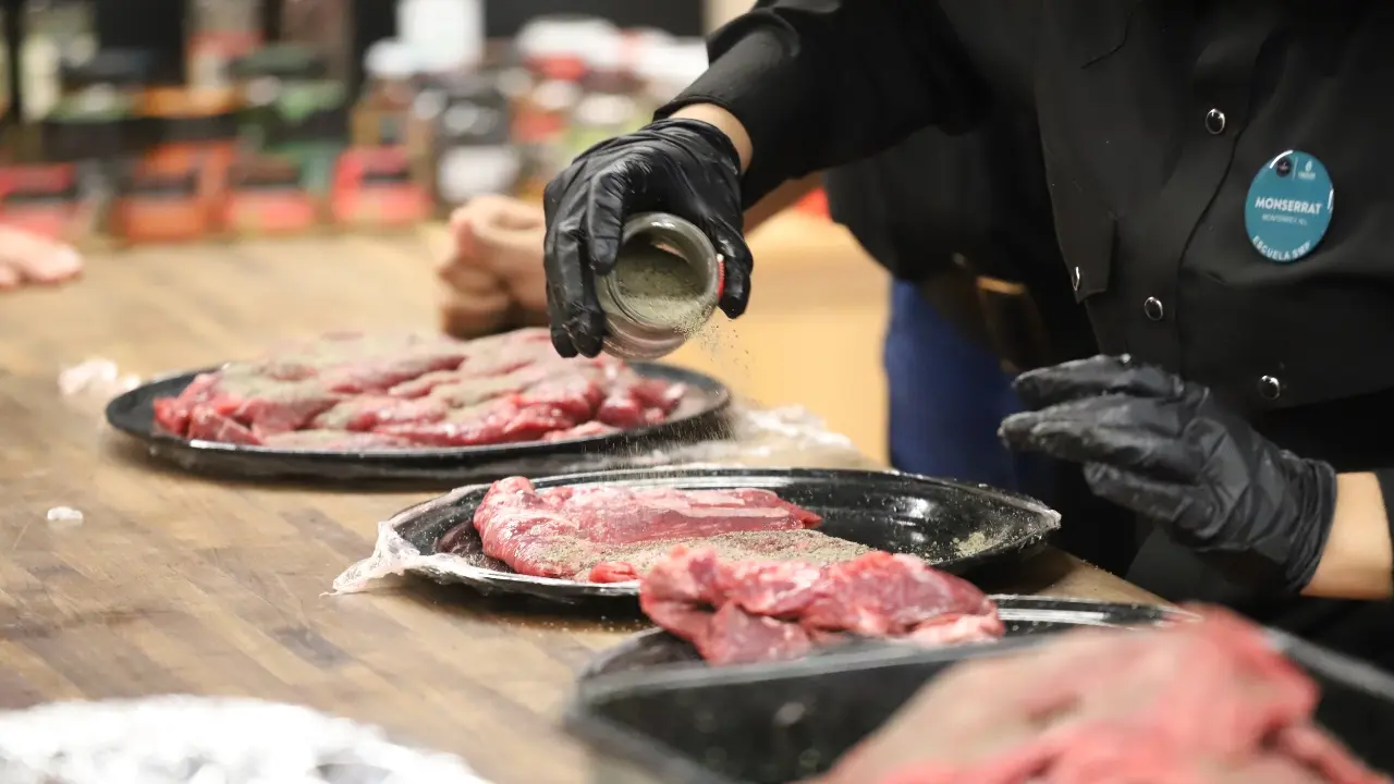 Un plato con carne y una persona sazonando. Foto: Gobierno de Nuevo León