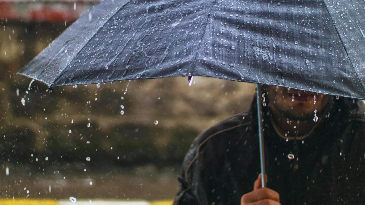 Una persona con un paraguas y lluvia. Foto: Canva
