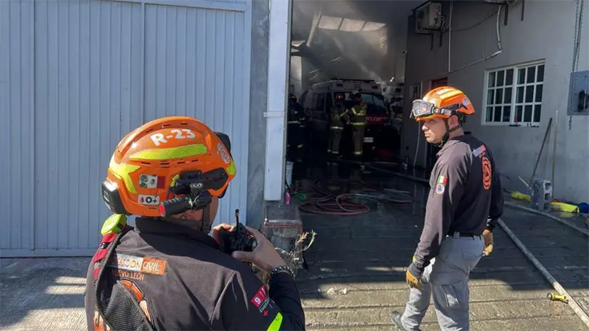 Elementos de Protección Civil de Nuevo León realizan labores de enfriamiento tras el incendio que consumió 4 ambulancias y un vehículo en una bodega de San Nicolás. Foto: Protección Civil de Nuevo León